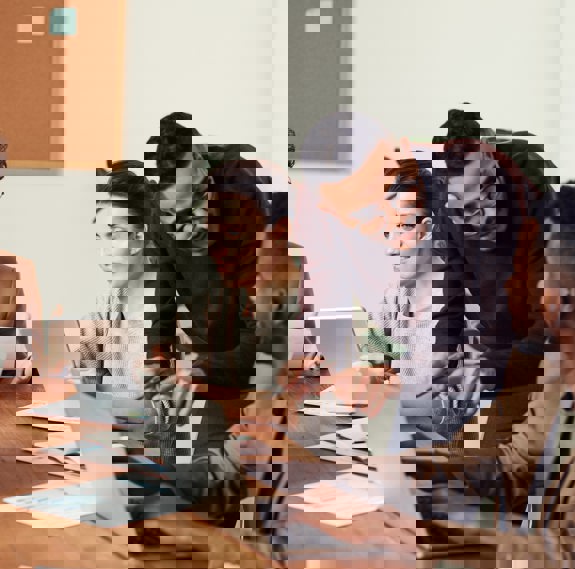 Three people on laptops and talking